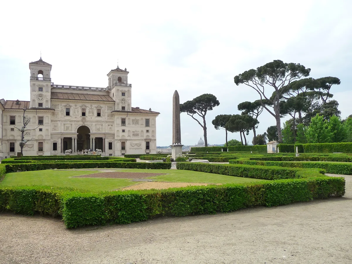 Giardino geometrico all'italiana di Villa Medici a Roma con siepi di bosso, obelisco centrale e la cupola di San Pietro sullo sfondo, esempio di giardino rinascimentale romano