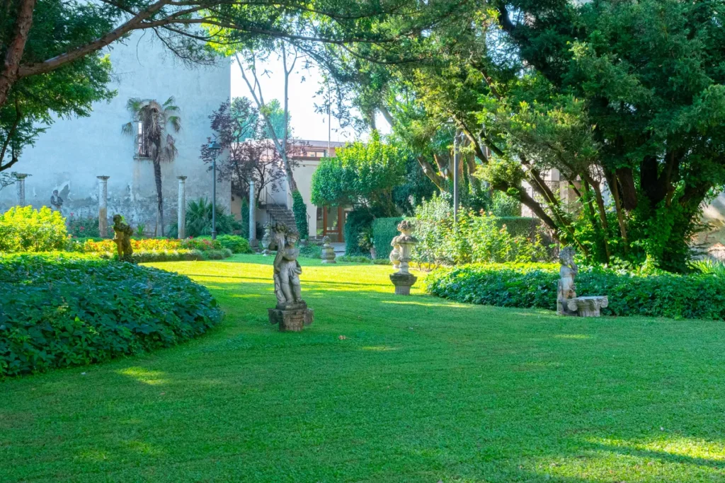 Prato con statue neoclassiche e alberi secolari, giardino Palazzo d'Arco Mantova