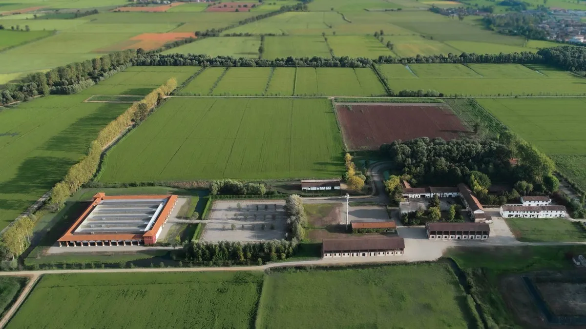 Veduta aerea dell'Innovation Center Giulio Natta a Giussago, circondato da campi agricoli e zone di forestazione.